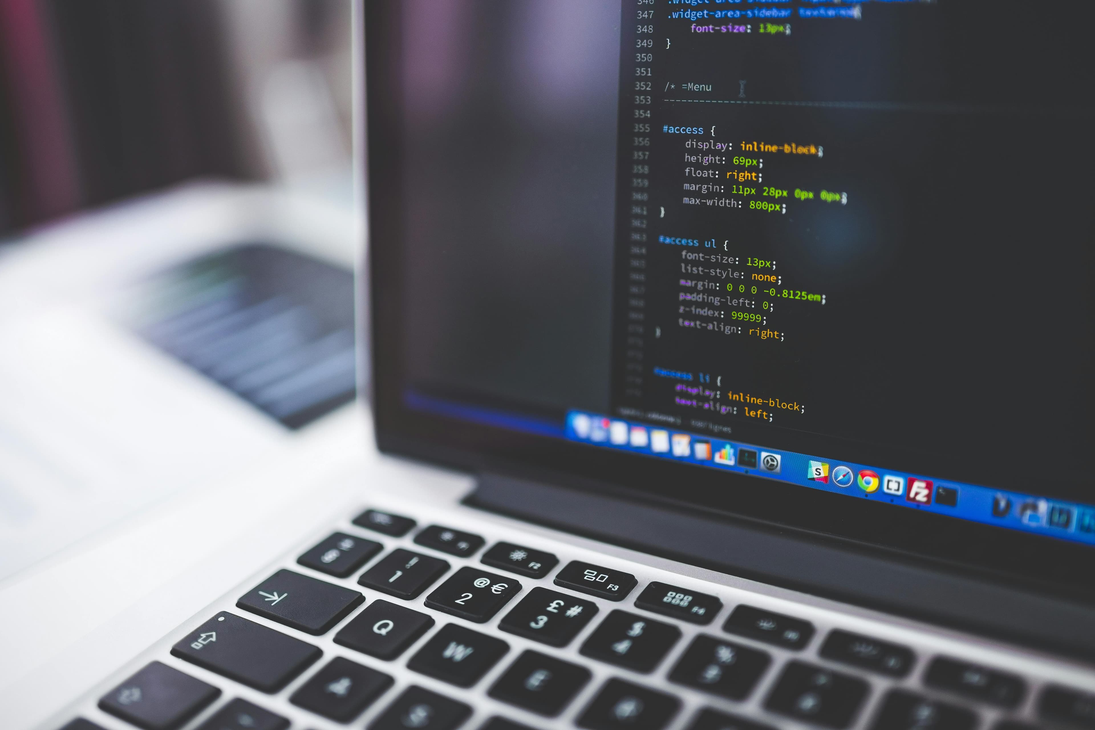 Close-up of CSS code on a laptop screen, suggesting technical implementation work.